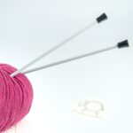 Ihlice DROPS Basic zapichnuté v klbku priadze, pripravené na pletenie.