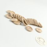 Viacero drevených gombíkov s nápisom Hand Made